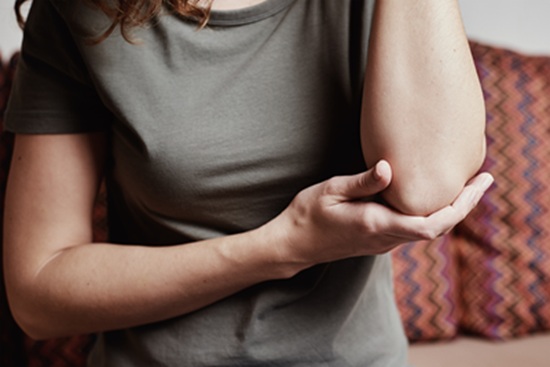 A woman suffering from tennis elbow pain